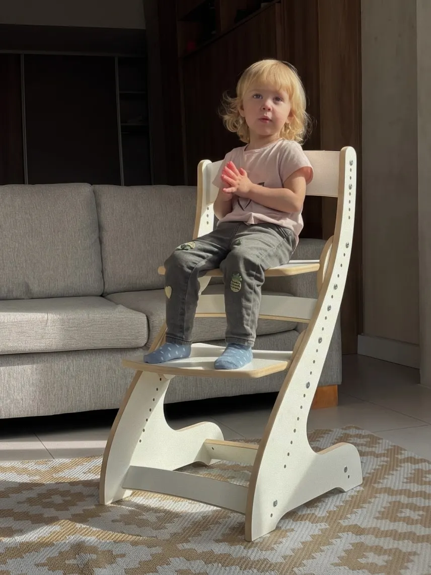Nena sentada en una silla evolutiva de Madera Más en el living de casa