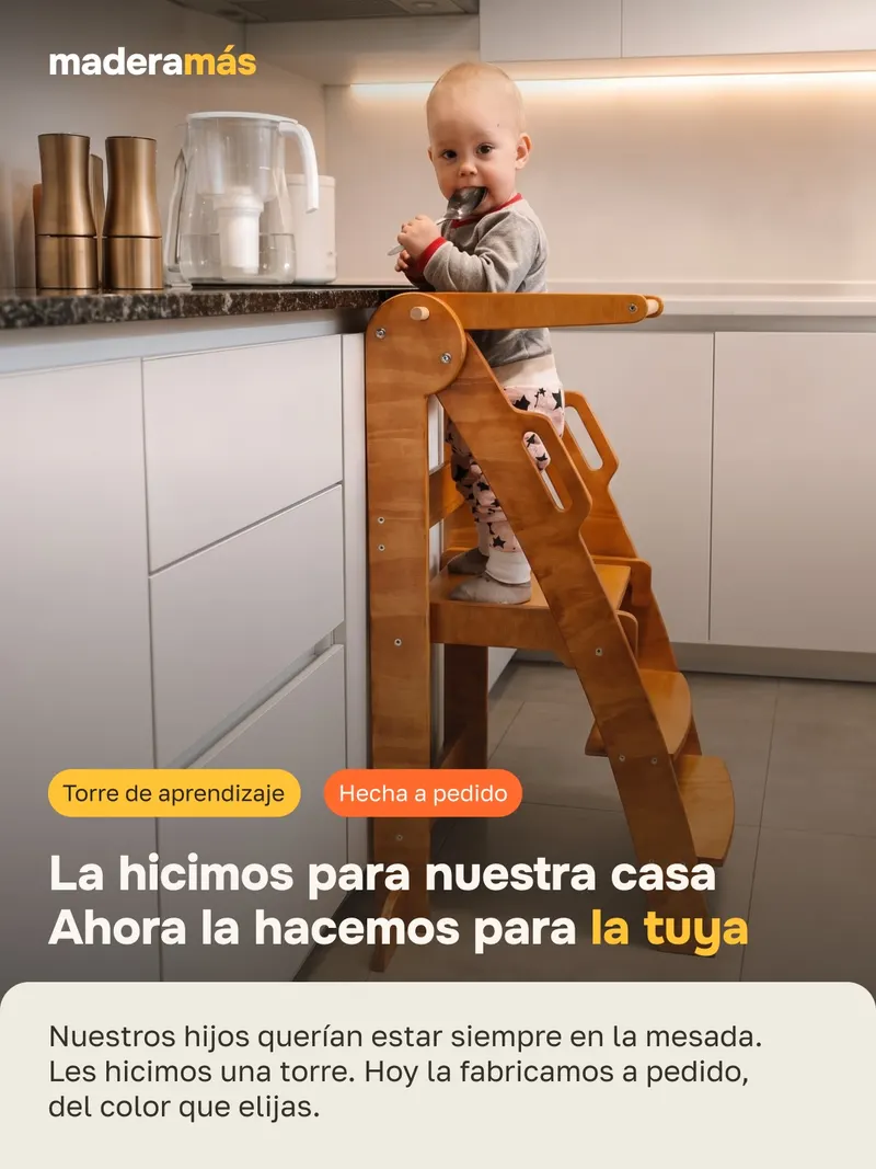 Bebé en la torre de aprendizaje, a la altura de la mesada de la cocina