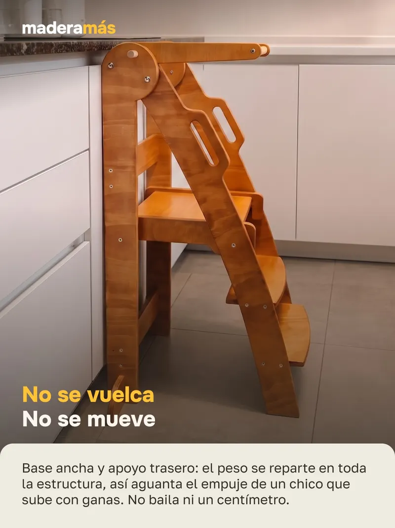 Bebé en la torre de aprendizaje, a la altura de la mesada de la cocina
