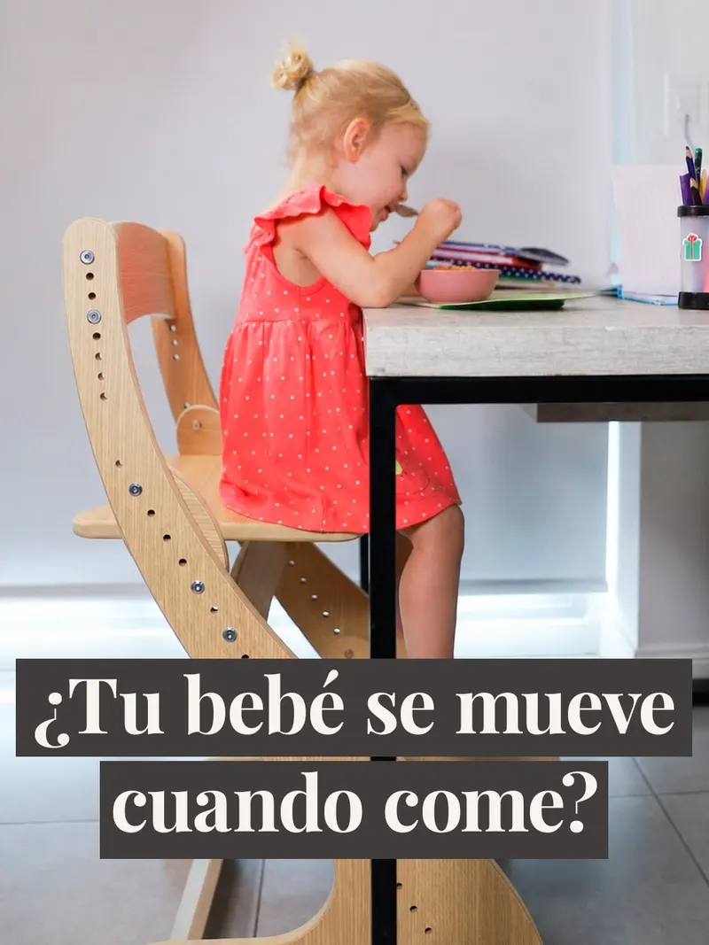 Nena dibujando en la mesa, sentada en una silla evolutiva de roble