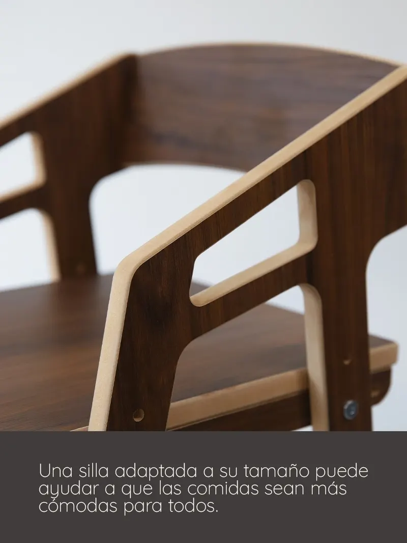 Nena dibujando en la mesa, sentada en una silla evolutiva de roble